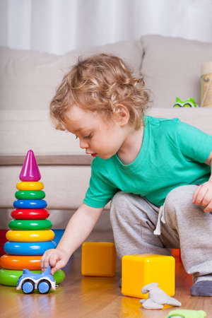 Little boy playing alone with colorful toysの写真素材