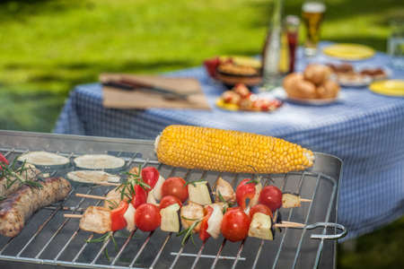 A garden reception with a set table and a grillの写真素材