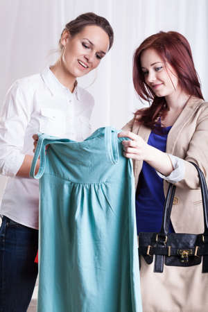 Female friends during viewing new dress, verticalの写真素材