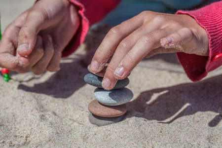 Placing a stack of rocks at seasideの写真素材