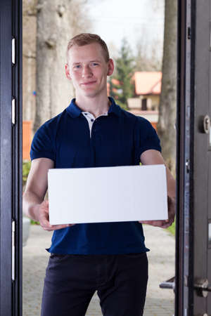 Order delivered by handsome and smiling courierの写真素材