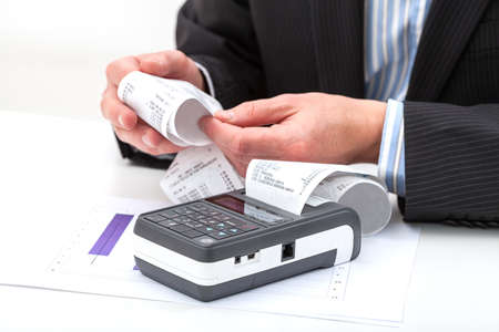 Businessman's hands holding long receipt from cash register