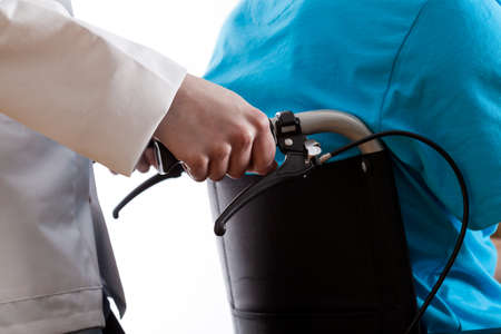 Close-up of nurse helping man in wheelchairの写真素材