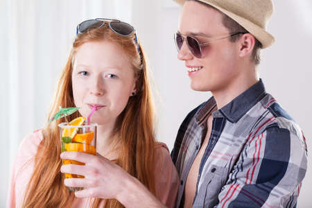 Red haired girl drinking fresh summer cocktail の写真素材