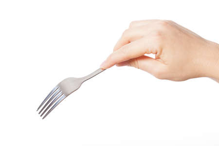 Hand holding silver fork and going to eat somethingの写真素材