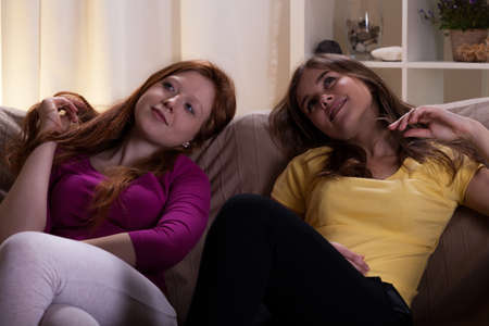 Best friends relaxing on the sofa in evening