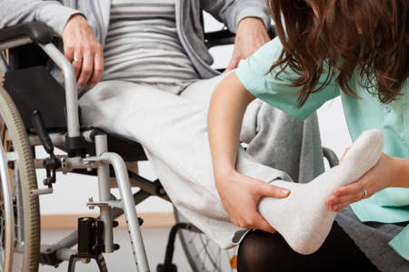 Disabled person during rehabilitation with her nurse