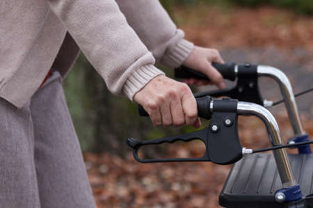 Elderly person during walking with walker, horizontal