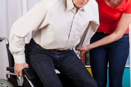 Guardian helping her disabled patient with sitting downの写真素材