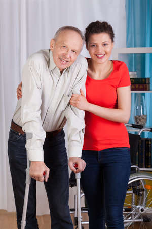 Disabled man standing with his nurse, vertical