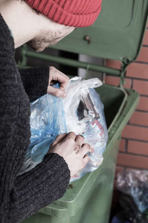 Homeless looking for something in a trashの写真素材