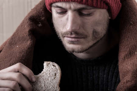 Homeless and poor man eating sandwich, horizontalの写真素材