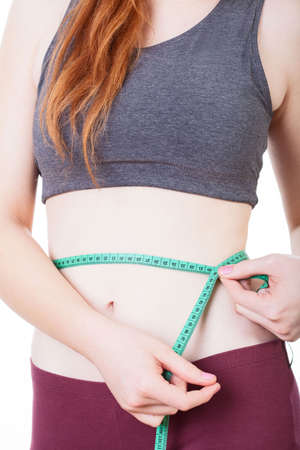 Close-up of a woman measuring her waistの写真素材