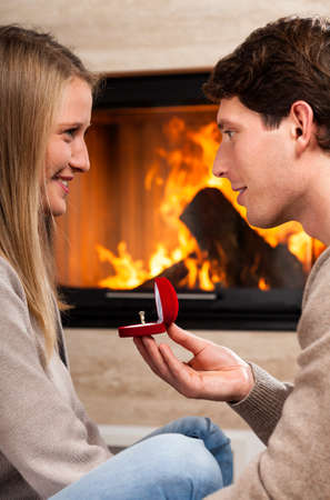 Happy man proposing to his girlfriend at home