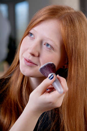 Young woman is getting her makeup done
