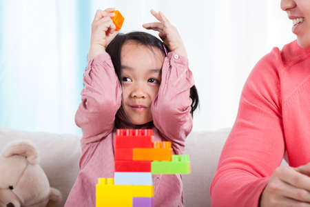 Little asian girl playing with a colorful blocksの写真素材