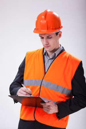A young handsome building site manager making notesの写真素材