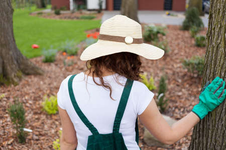 Woman standing in her beautiful garden, horizontalの写真素材