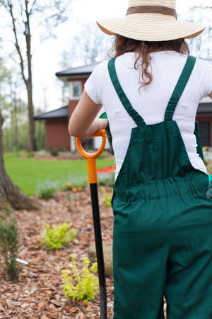 Woman resting after work in garden and keeping spadeの写真素材