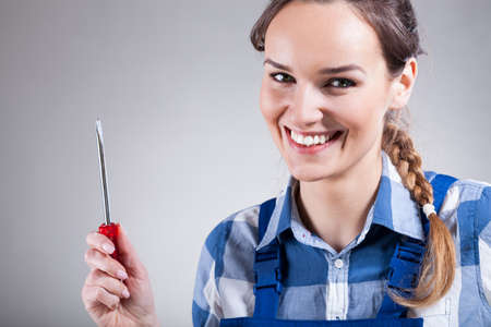Smiling, beautiful woman with a screwdriver, horizontalの写真素材