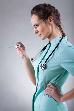 Female doctor with a thermometer on isolated backgroundの写真素材