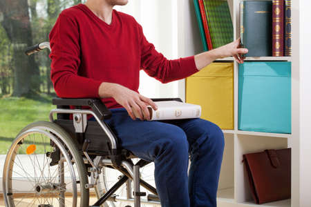 Disabled man on wheelchair clearing out documentsの写真素材