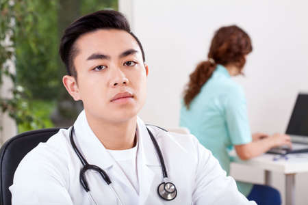 Horizontal view of a working asian doctorの写真素材