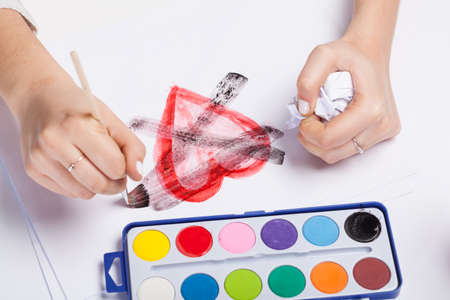 Crossed heart painted paints on a piece of paperの写真素材