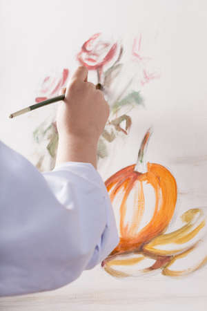 Woman's hand painted a still life on a white canvasの写真素材