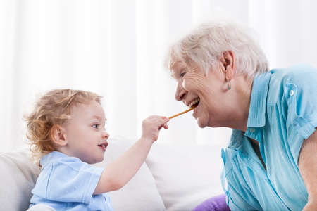 Grandson and his grandma eating together, horizontalの写真素材