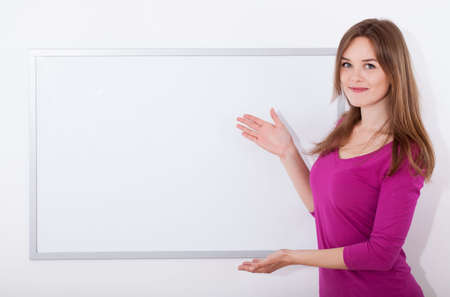 Beautiful young student showing a blank boardの写真素材