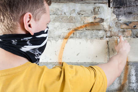 Hooligan painting graffiti on the wall, horizontalの写真素材