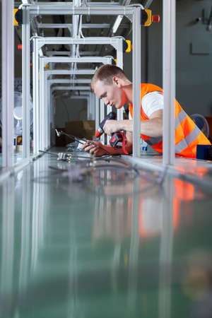 Worker with cordless screwdriver at production areaの写真素材