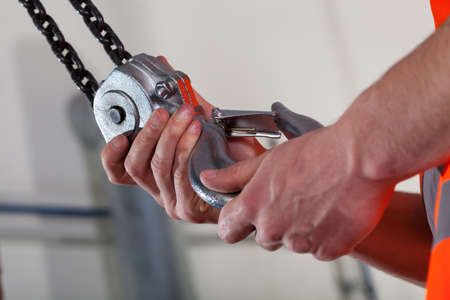 Close-up of male hands and lifting hook, horizontalの写真素材