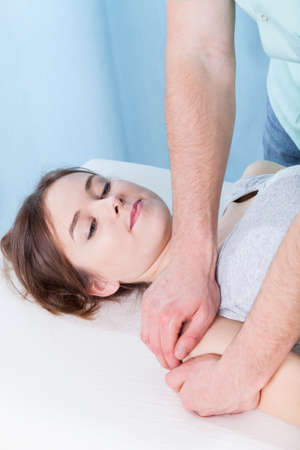 Young girl during massaging her arm, verticalの写真素材