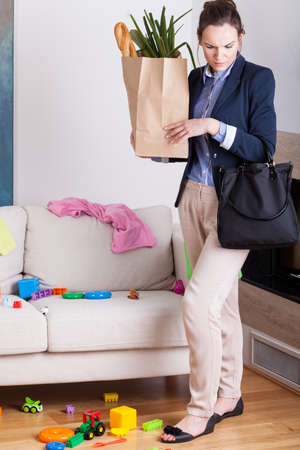 Woman returned home from shopping and looking at the mess in the room