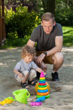 Dad and son having fun on playgroundの写真素材