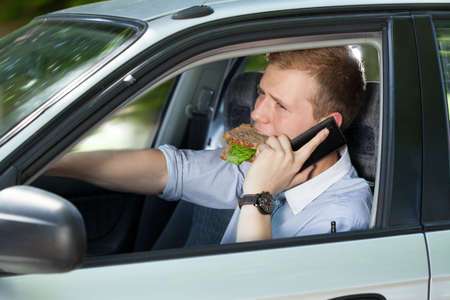 Busy man driving a car and talking phone