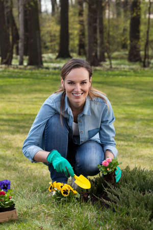 Portrait of a beautiful woman kneeling during working in gardenの写真素材