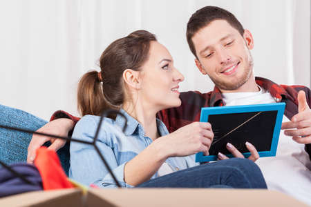 Couple packing to move house and looking at family photoの写真素材