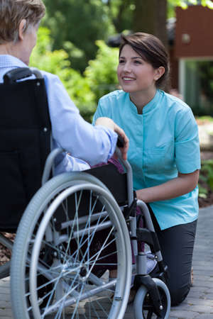 Nurse and disabled woman resting in a gardenの写真素材