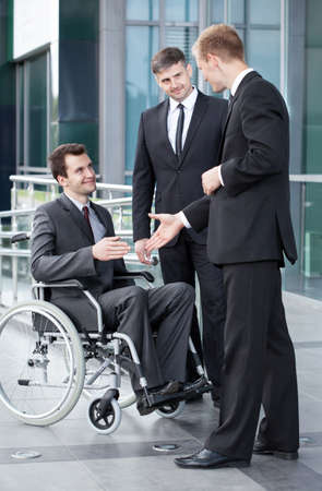 Man on wheelchair before business meeting, verticalの写真素材