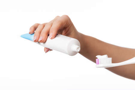 Hand holding toothpaste and toothbrush on isolated backgroundの写真素材