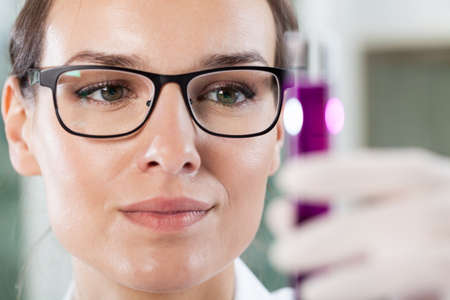 Close-up of a woman holding a test tube with chemicalsの写真素材