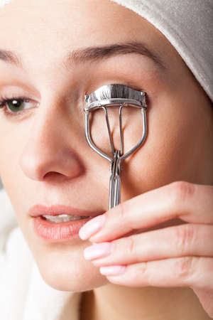 Woman using curler to have beautiful eyelashesの写真素材