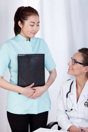Caucasian female doctor and young Asian assistant, verticalの写真素材