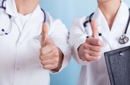Close-up of a doctors showing thumbs up sign, horizontalの写真素材