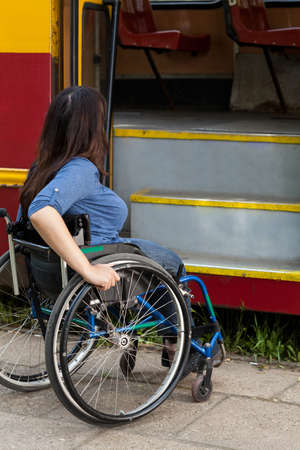 Woman of wheelchair having problem with public transport, verticalの写真素材