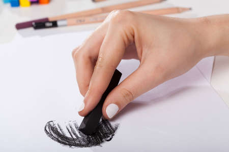 Close-up of woman's hand painted by a black pastelの写真素材