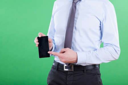 Man showing data on smartphone on green backgroundの写真素材